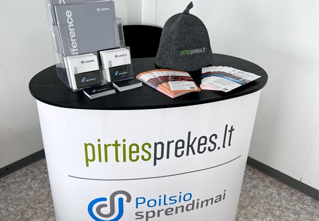 edukacinis stalas su pirties prekiu logotipais, lankstinukais ir informaciniais zurnalais