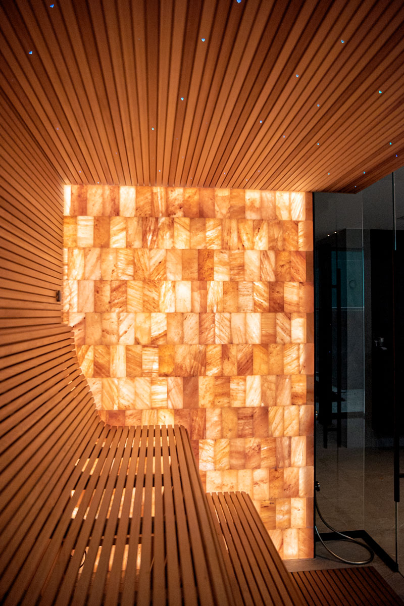 Illuminated Himalayan salt brick wall and starry sauna ceiling.